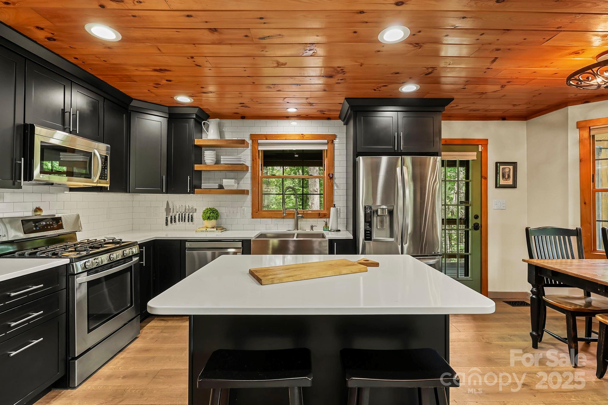 228 Woodby Ridge Road Vilas, NC 28692 - Photo 11 of 46 a kitchen with a stove a sink dishwasher a refrigerator with wooden cabinets and floor