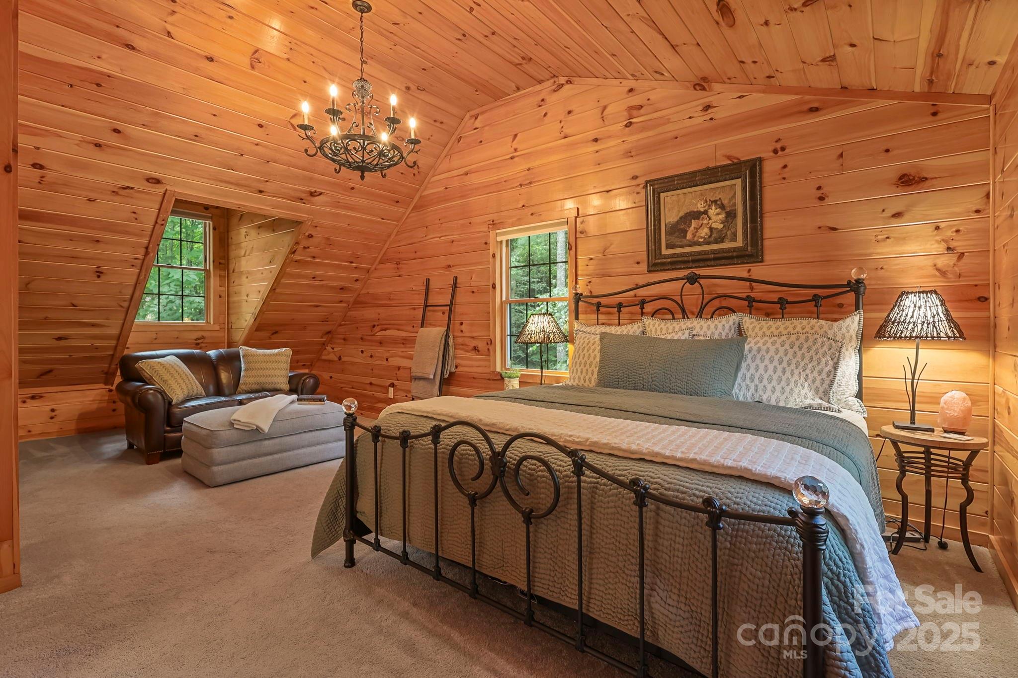 228 Woodby Ridge Road Vilas, NC 28692 - Photo 27 of 46 a bedroom with furniture and a chandelier