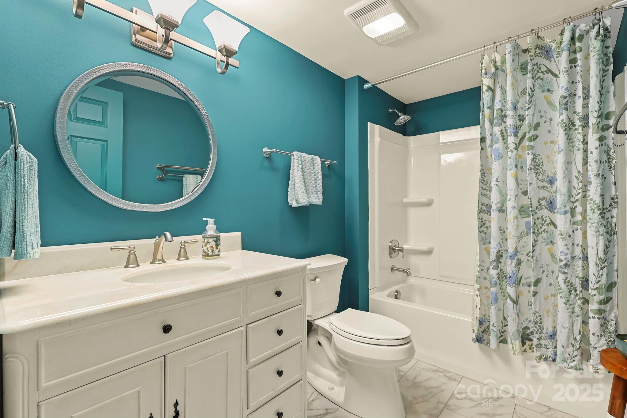 228 Woodby Ridge Road Vilas, NC 28692 - Photo 34 of 46 a bathroom with a toilet sink vanity and mirror