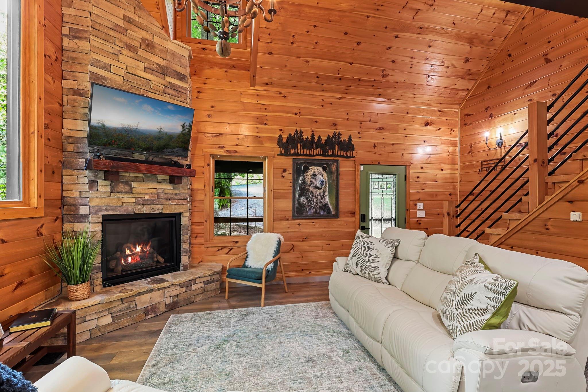 228 Woodby Ridge Road Vilas, NC 28692 - Photo 6 of 46 a living room with furniture a flat screen tv and a fireplace