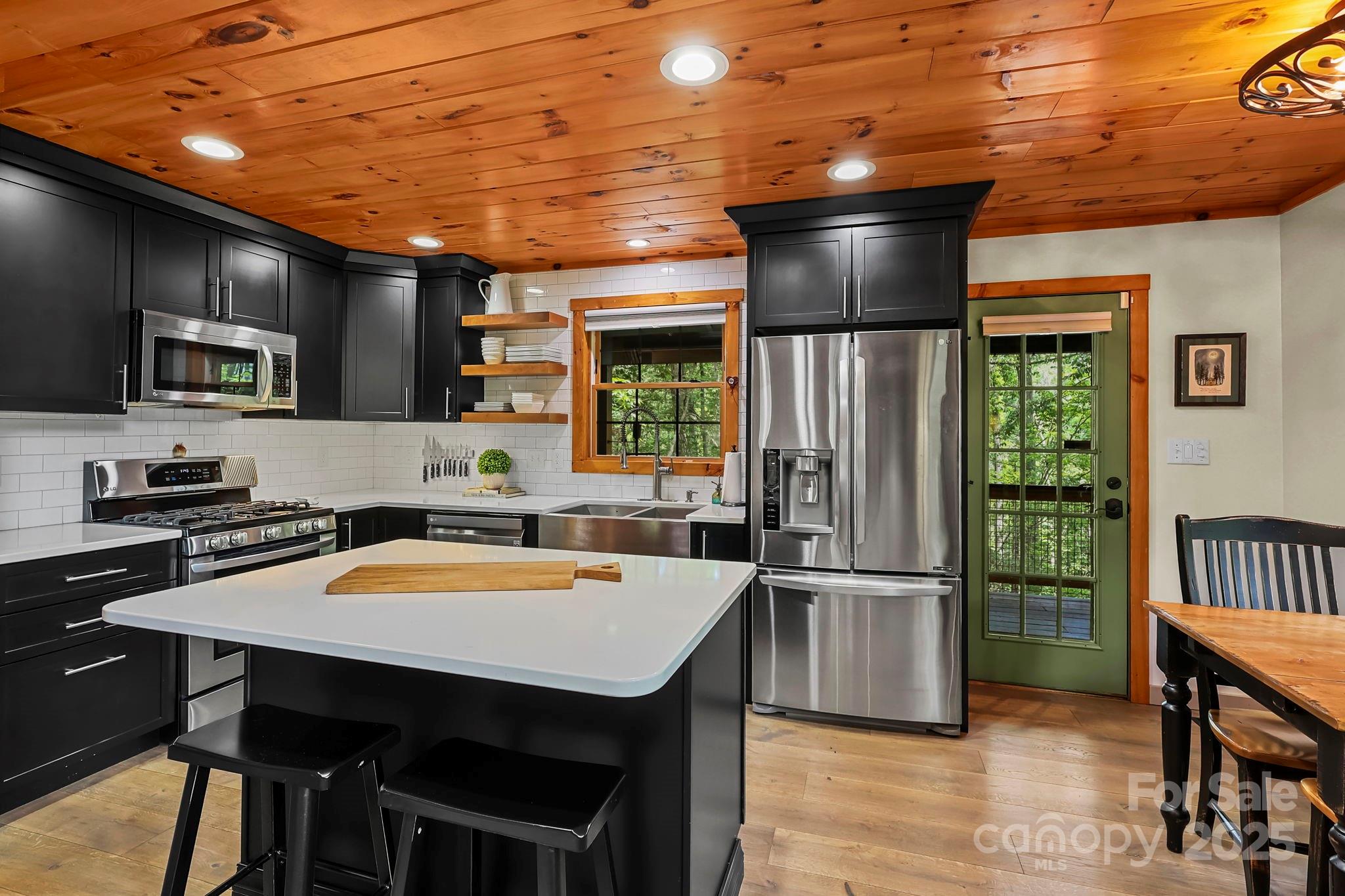 228 Woodby Ridge Road Vilas, NC 28692 - Photo 8 of 46 a kitchen with stainless steel appliances granite countertop a sink refrigerator stove dining table and chairs
