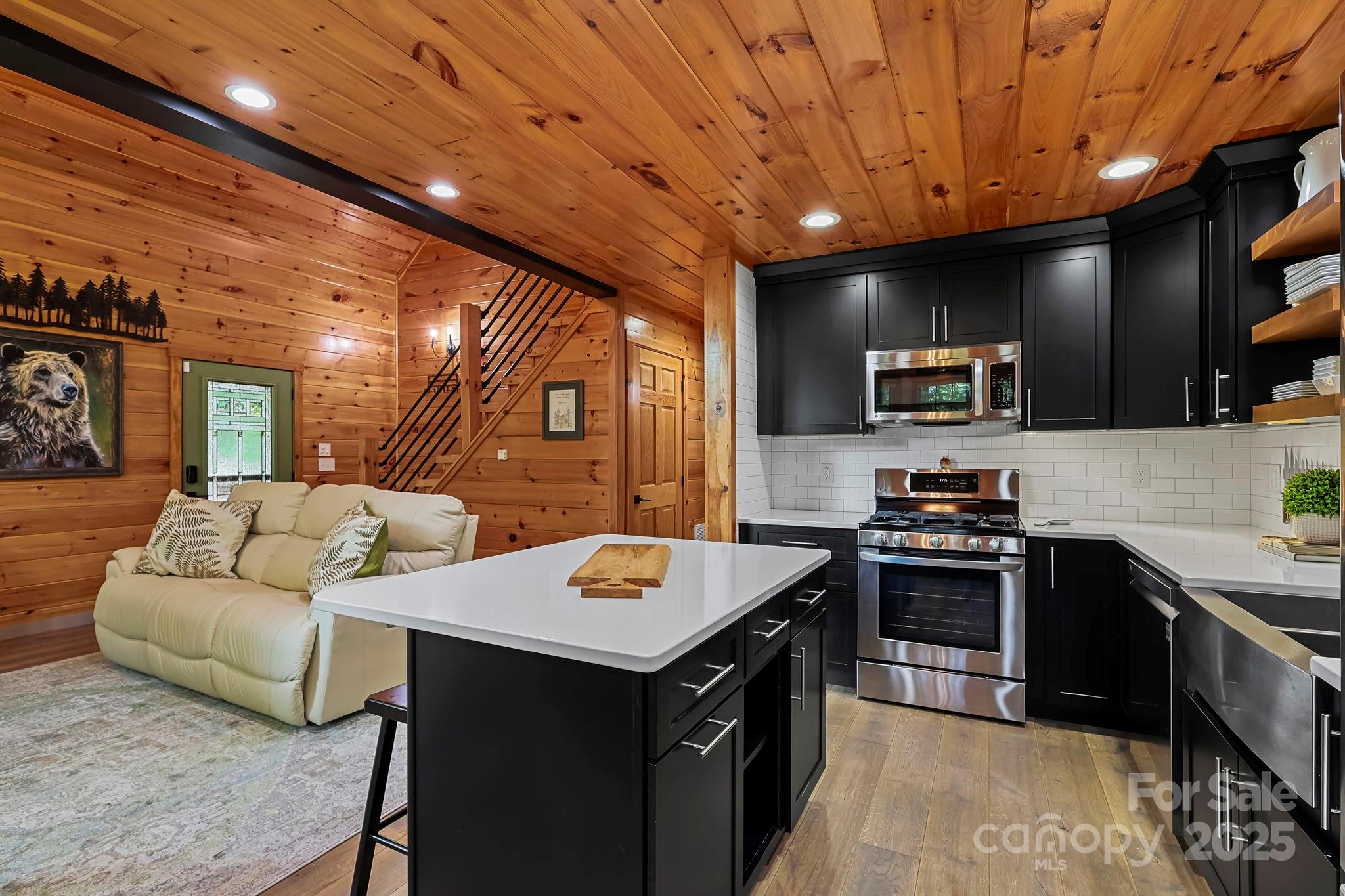 228 Woodby Ridge Road Vilas, NC 28692 - Photo 9 of 46 a kitchen with a stove a sink dishwasher a oven with a dining table and chairs with wooden floor