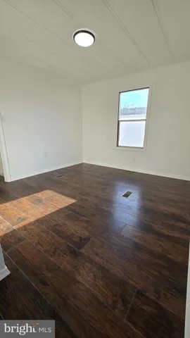 a view of a room with wooden floor and window