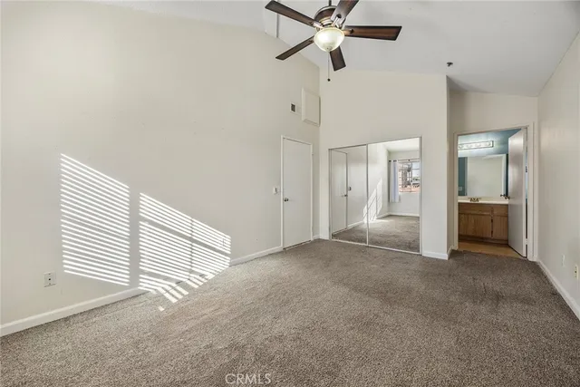 an empty room with a ceiling fan and window