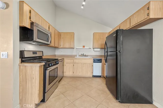 a kitchen with stainless steel appliances granite countertop a refrigerator stove a sink and a microwave