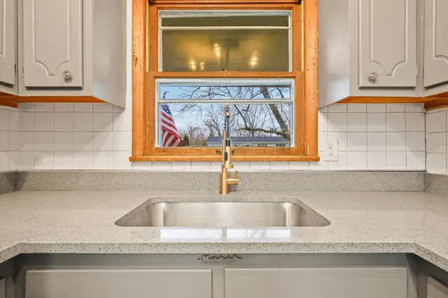 a kitchen with a sink a stove a refrigerator and a window