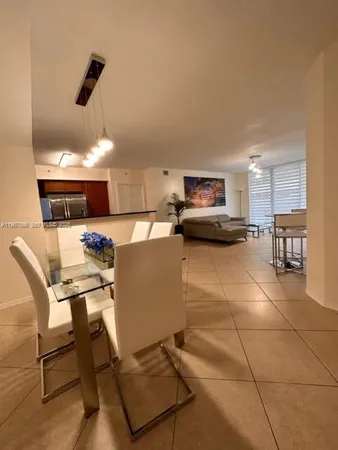 a kitchen with a dining table cabinets and stainless steel appliances