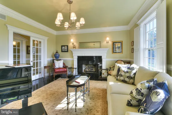 a dining room with furniture a chandelier and wooden floor