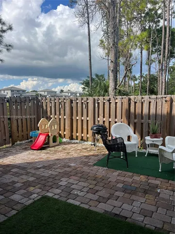 a backyard of a house with table and chairs