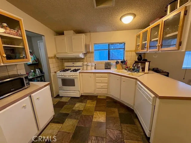 a kitchen with a sink a stove and cabinets
