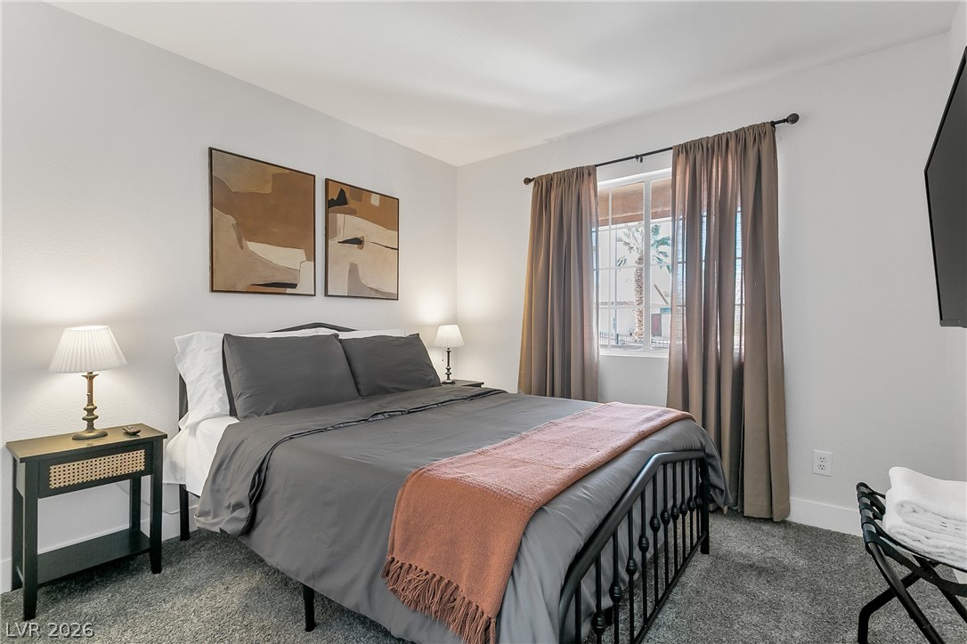 101 Beaver Ridge Avenue North Las Vegas, NV 89031 - Photo 24 of 42 A well-lit primary bedroom features soft carpet and ample window light, creating a calming retreat.