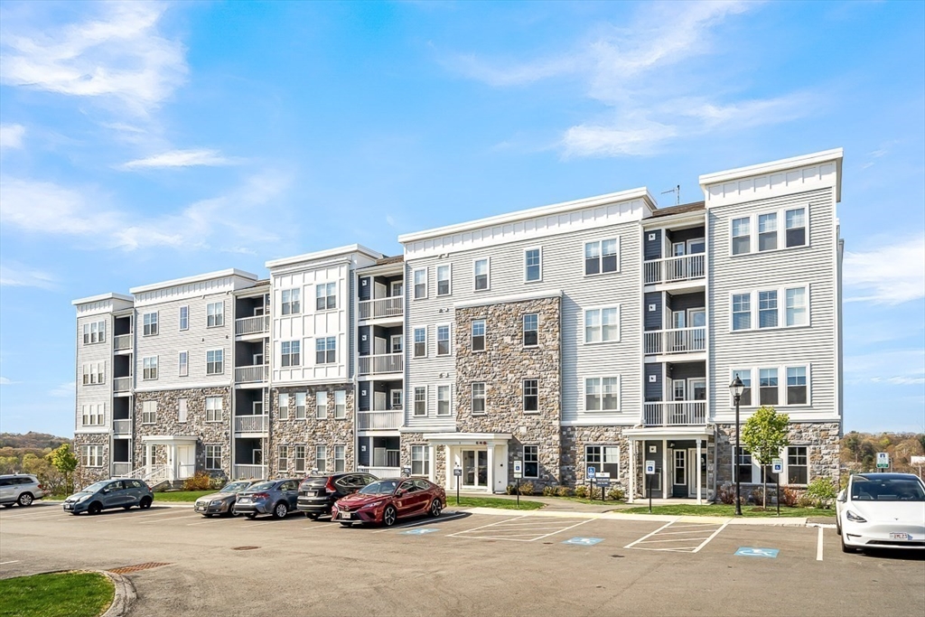2 Stratton Drive, Unit 307 Woburn, MA 01801 - Photo 20 of 21 a front view of a building with lot of cars and trees
