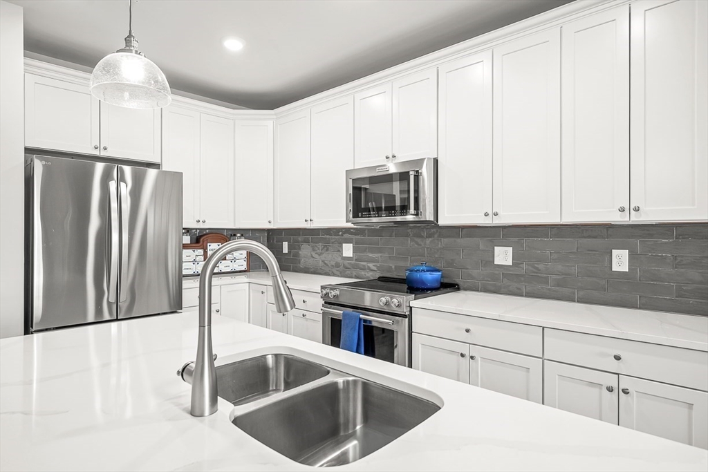 2 Stratton Drive, Unit 307 Woburn, MA 01801 - Photo 8 of 21 a kitchen with stainless steel appliances granite countertop a sink a stove a refrigerator and cabinets with wooden floor