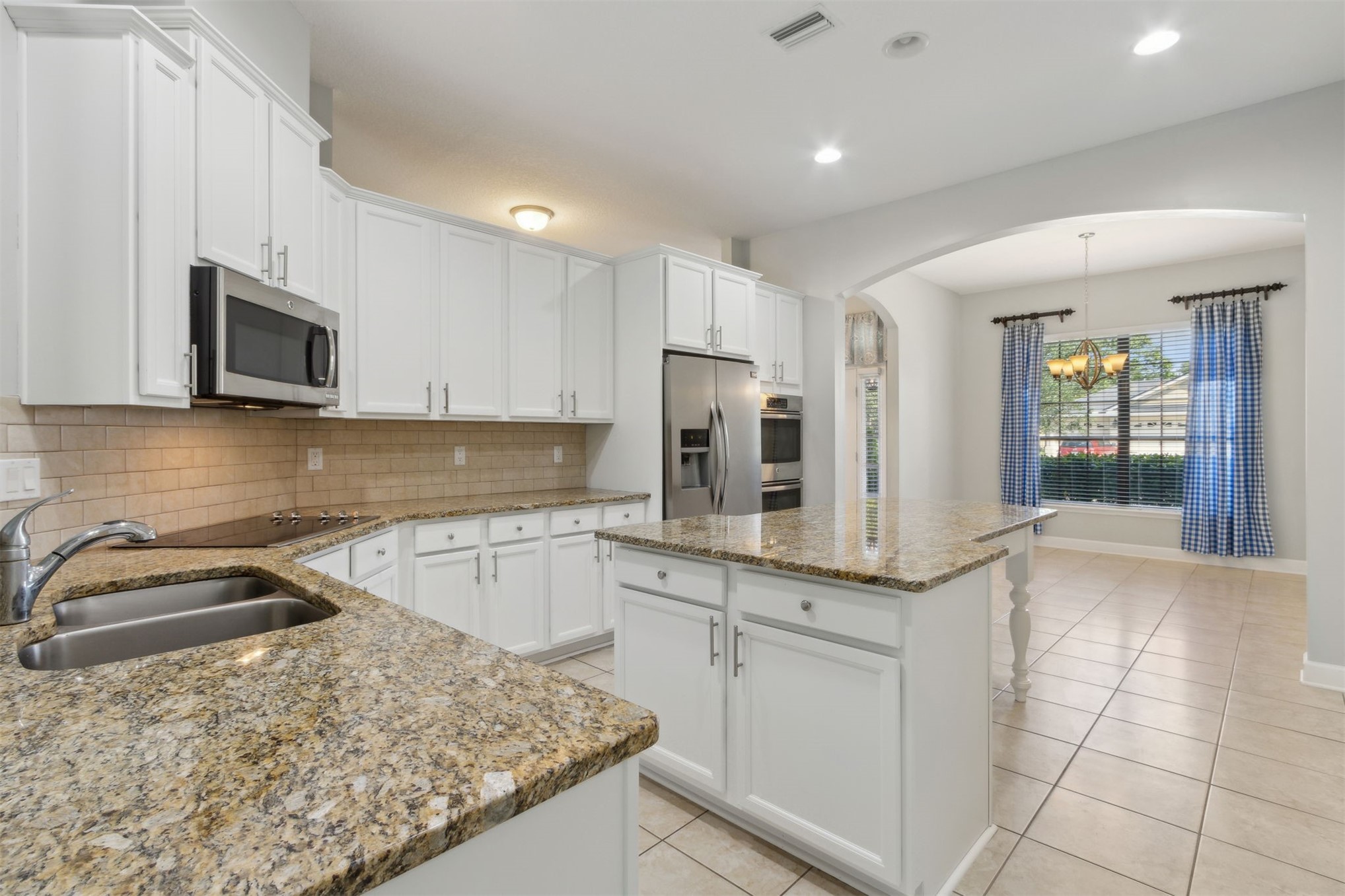 33146 Prairie Parke Place Fernandina Beach, FL 32034 - Photo 5 of 28 a kitchen with stainless steel appliances granite countertop a sink and a stove