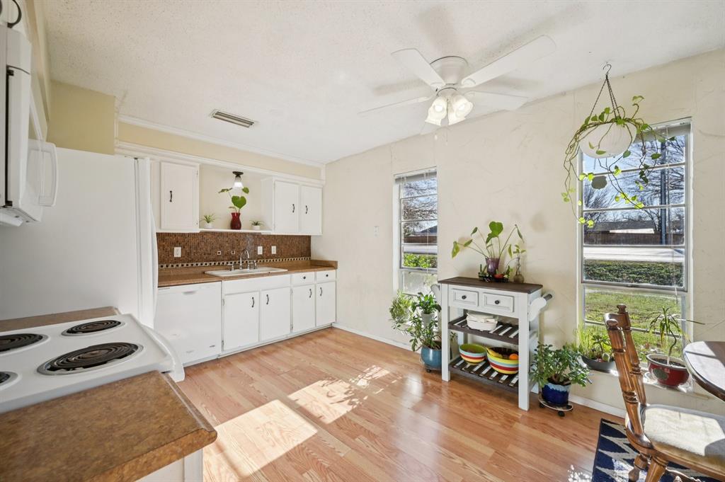 1021 Pleasant Valley Road Garland, TX 75040 - Photo 15 of 32 a kitchen with stainless steel appliances a stove a chimney a sink and cabinets