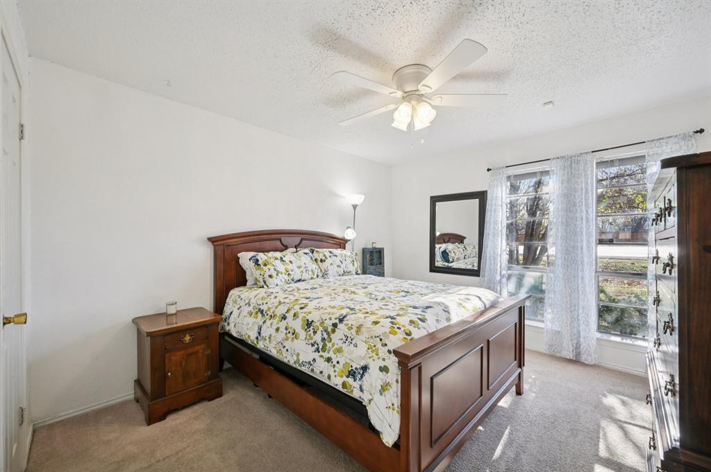 1021 Pleasant Valley Road Garland, TX 75040 - Photo 16 of 32 a bedroom with a bed and a chandelier