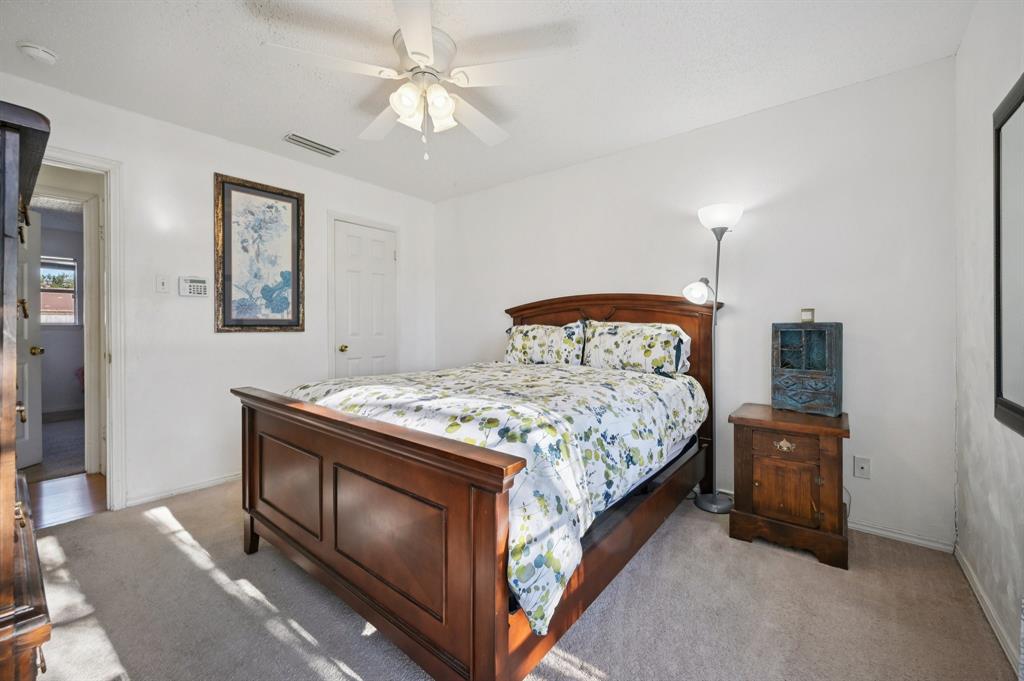 1021 Pleasant Valley Road Garland, TX 75040 - Photo 19 of 32 a bedroom with a bed and a chandelier