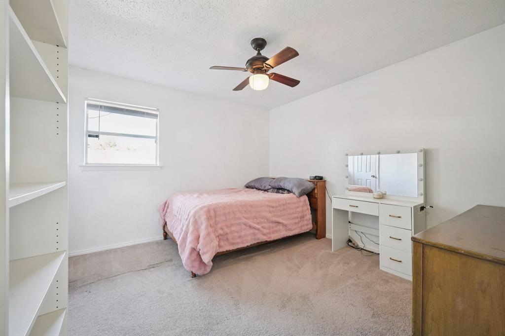 1021 Pleasant Valley Road Garland, TX 75040 - Photo 20 of 32 a bedroom with a bed and a chandelier