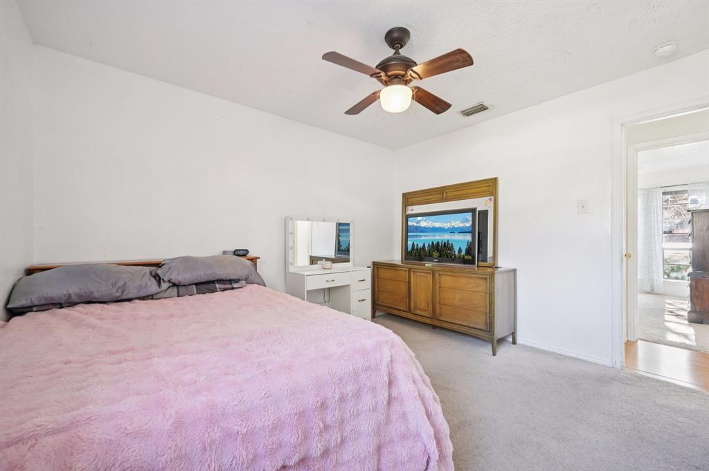 1021 Pleasant Valley Road Garland, TX 75040 - Photo 21 of 32 a bedroom with a bed and a chandelier