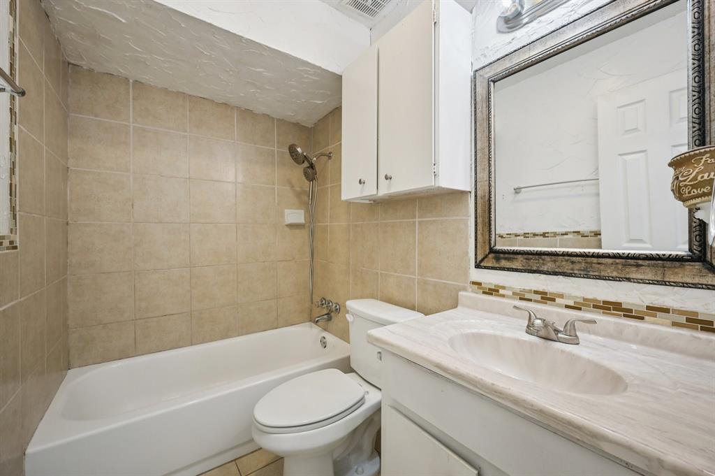 1021 Pleasant Valley Road Garland, TX 75040 - Photo 22 of 32 a bathroom with a sink a toilet and a bathtub