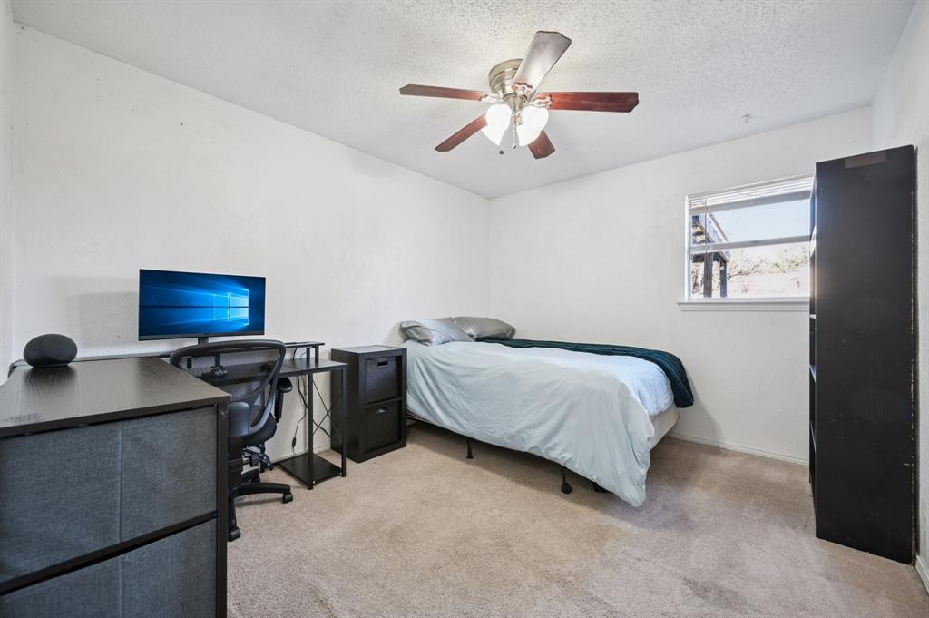 1021 Pleasant Valley Road Garland, TX 75040 - Photo 23 of 32 a bedroom with a bed furniture and a flat screen tv