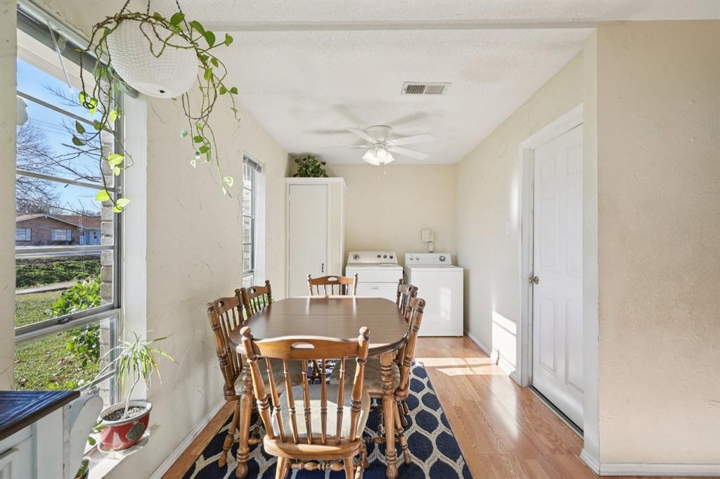1021 Pleasant Valley Road Garland, TX 75040 - Photo 9 of 32 a view of a dining room with furniture window and wooden floor