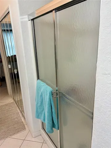a bathroom with a glass door shower and a mirror