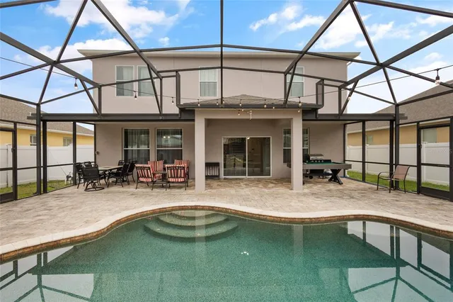 a swimming pool with table and chairs