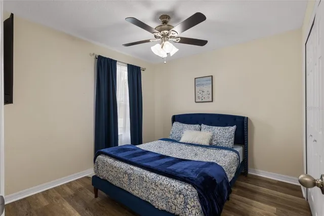 a bedroom with a large bed and a ceiling fan