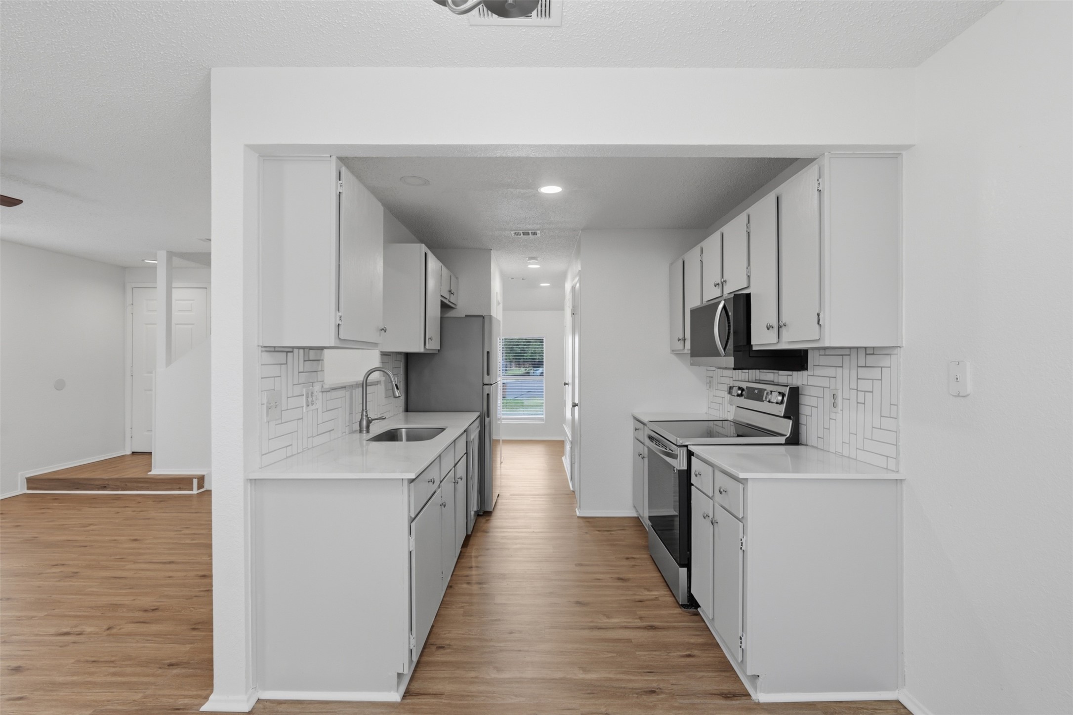 6105 Conti Court, Unit A Austin, TX 78744 - Photo 10 of 36 a kitchen with stainless steel appliances granite countertop a sink stove and refrigerator