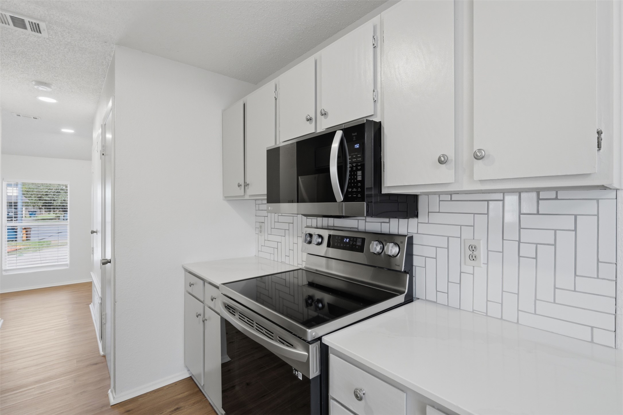 6105 Conti Court, Unit A Austin, TX 78744 - Photo 15 of 36 a kitchen with a stove and a microwave