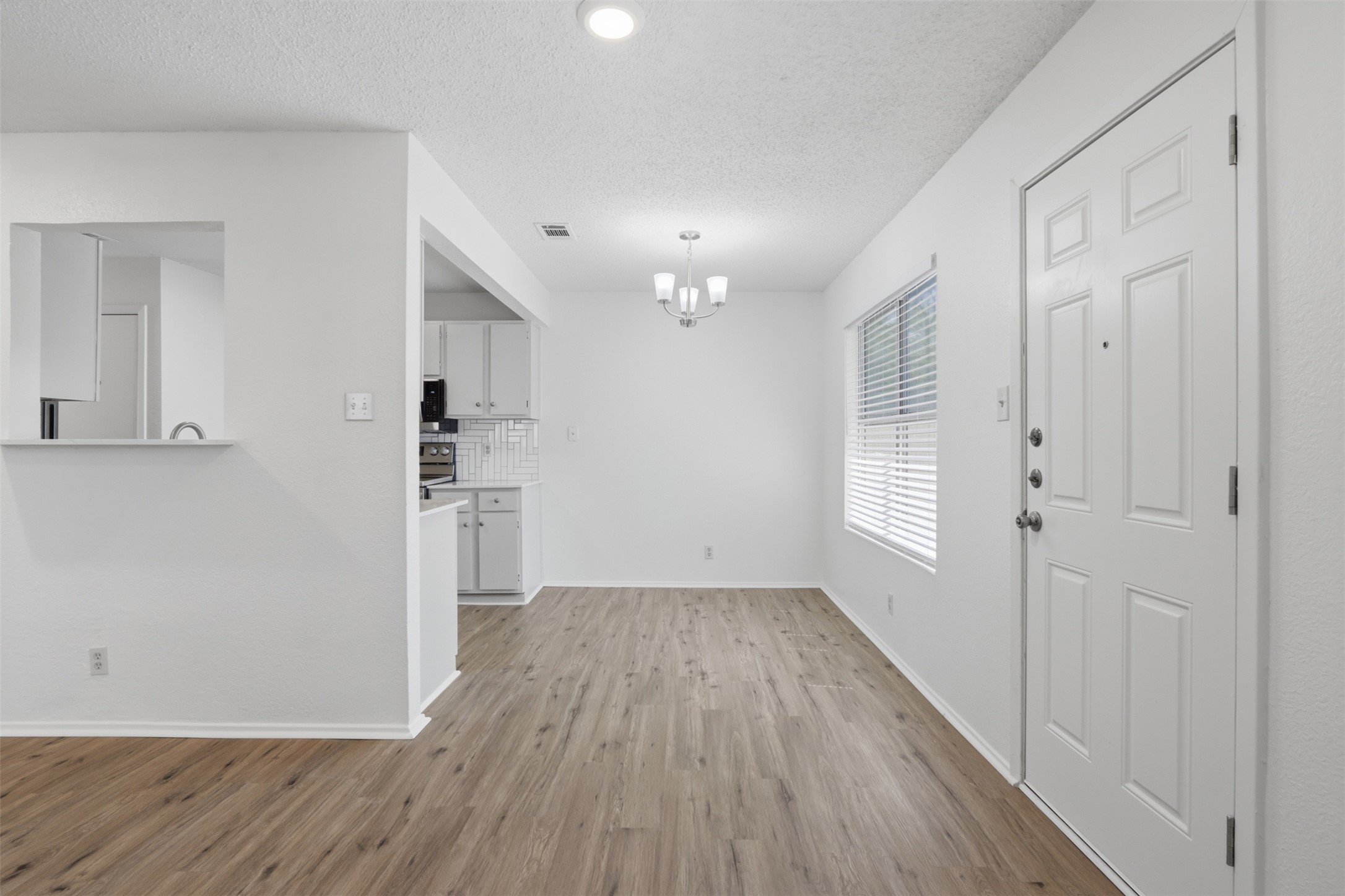 6105 Conti Court, Unit A Austin, TX 78744 - Photo 8 of 36 a view of a kitchen with wooden floor and a refrigerator