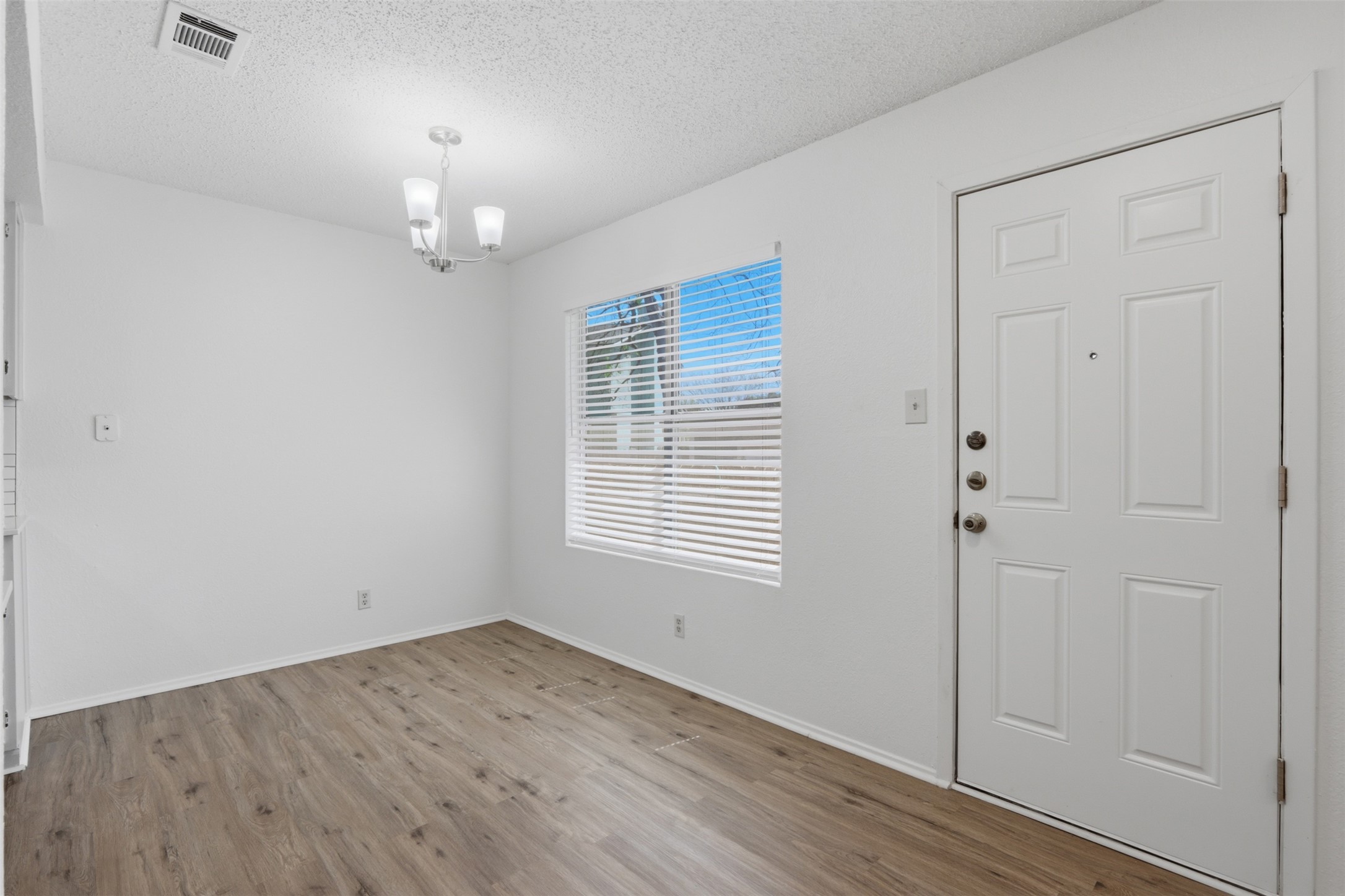 6105 Conti Court, Unit A Austin, TX 78744 - Photo 9 of 36 an empty room with wooden floor and window