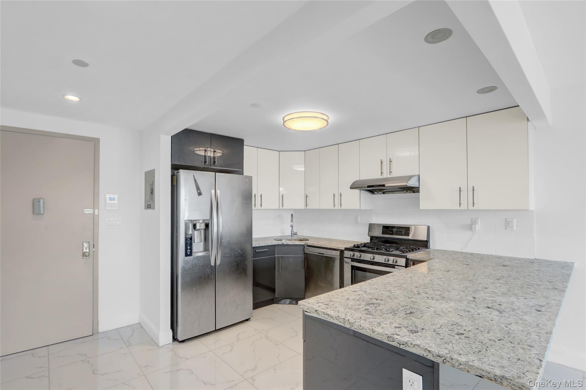 45-16 83rd Street, Unit W7C Queens, NY 11373 - Photo 5 of 16 a kitchen with stainless steel appliances granite countertop a refrigerator a stove and a sink