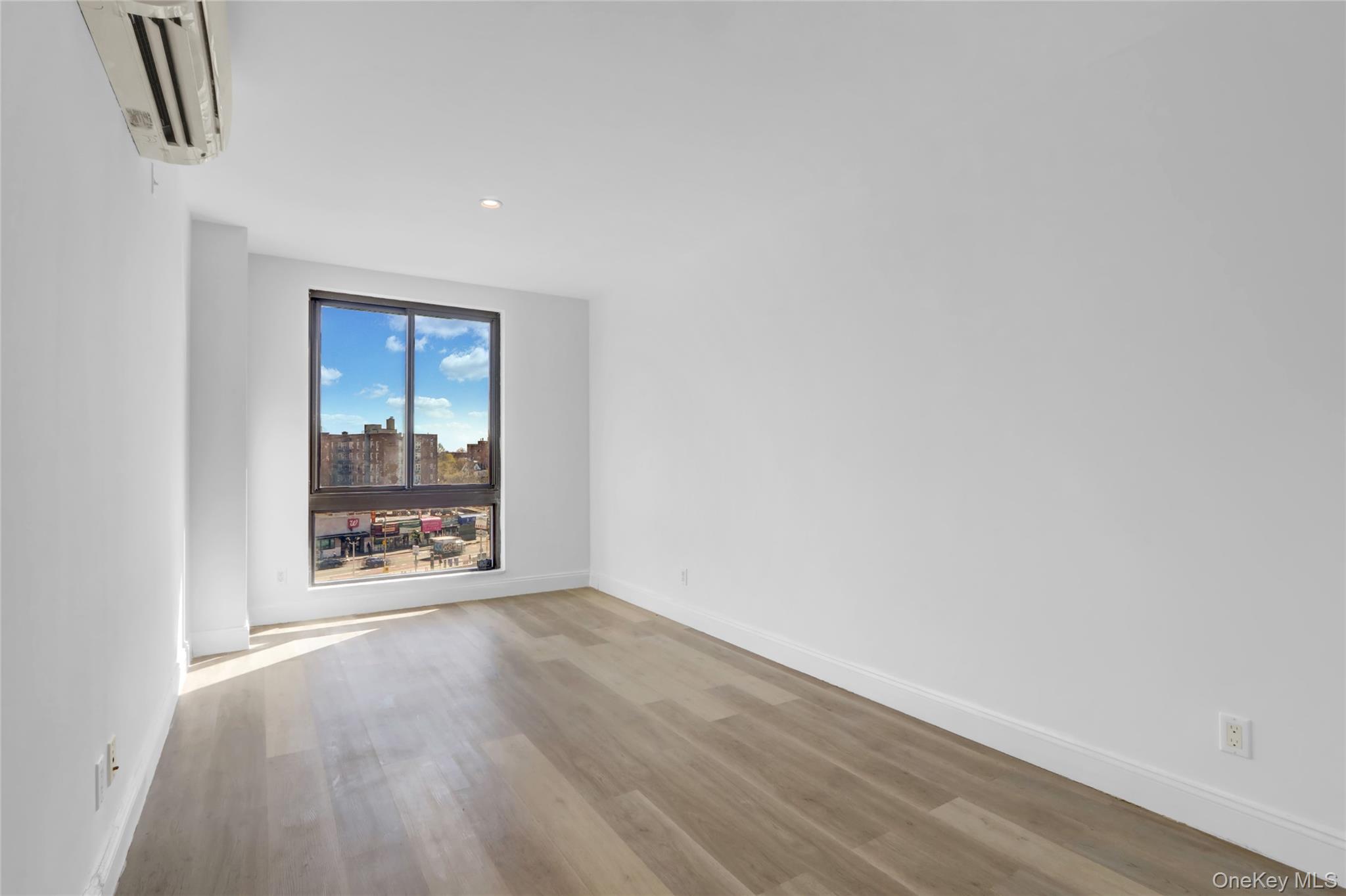 45-16 83rd Street, Unit W7C Queens, NY 11373 - Photo 8 of 16 a view of an empty room and wooden floor