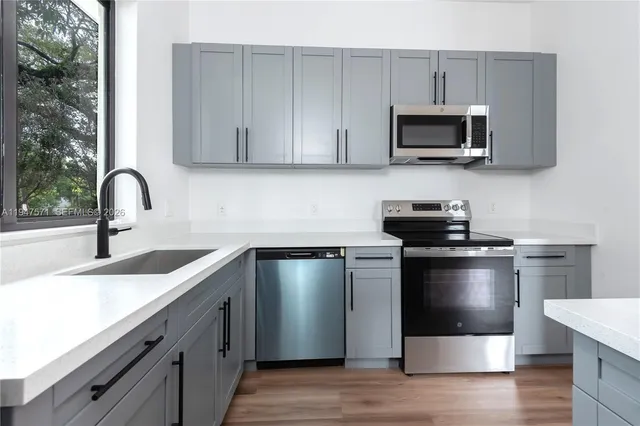a kitchen with appliances a sink and cabinets