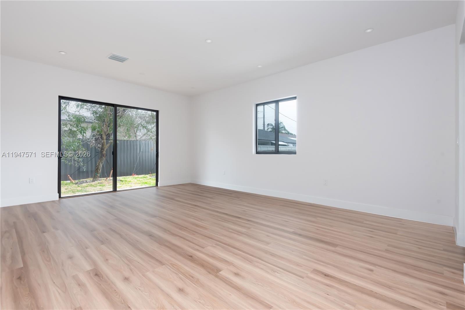 4517 Northwest 3rd Street Miami, FL 33126 - Photo 13 of 34 a view of an empty room with wooden floor and a window