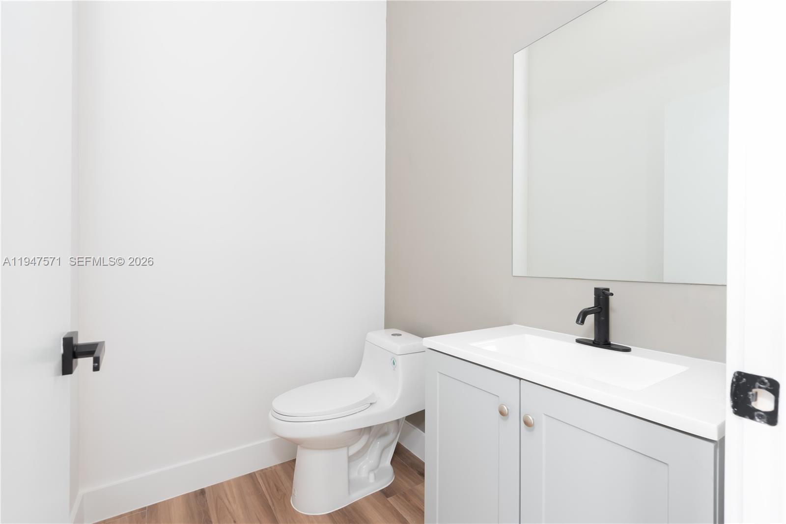 4517 Northwest 3rd Street Miami, FL 33126 - Photo 15 of 34 a bathroom with a sink a toilet and mirror