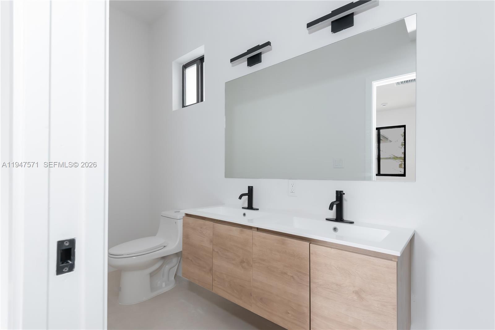 4517 Northwest 3rd Street Miami, FL 33126 - Photo 24 of 34 a bathroom with a toilet sink and mirror