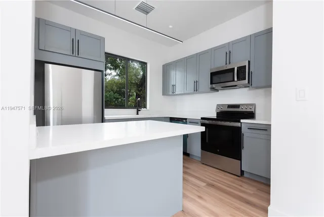 a kitchen with stainless steel appliances a microwave sink and refrigerator