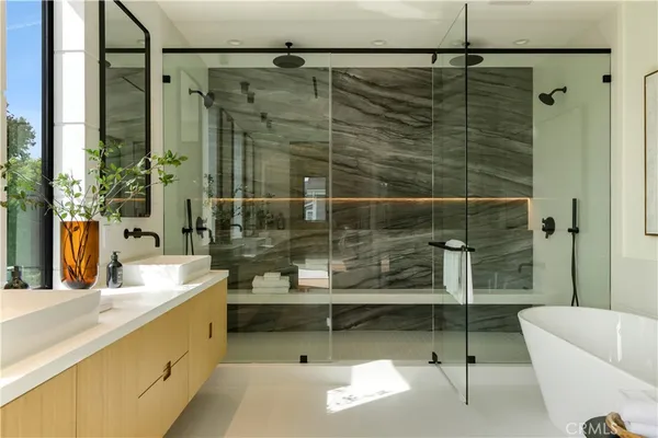a bathroom with a tub mirror and sink