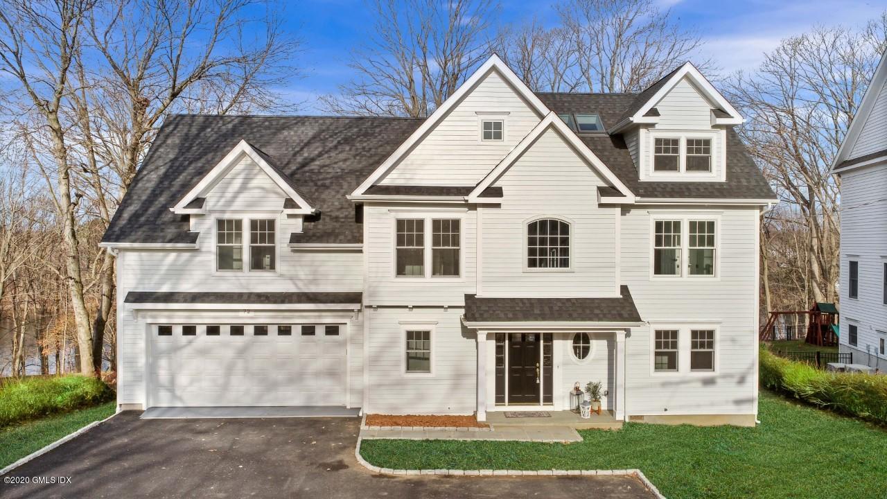 72 Riverside Lane Riverside, CT 06878 - Photo 2 of 40 a view of a white house next to a yard with big trees