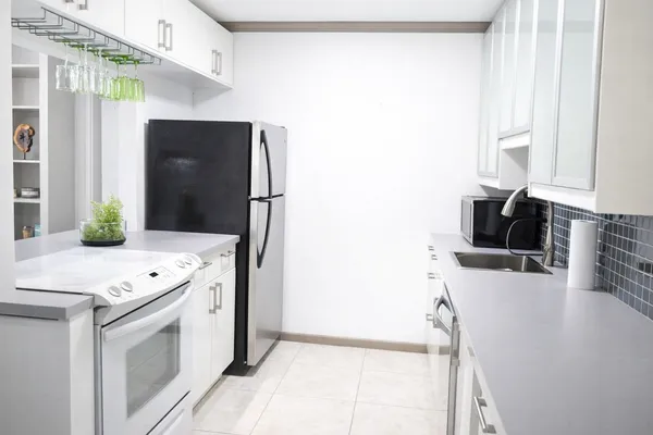 a kitchen with stainless steel appliances a stove refrigerator sink and microwave