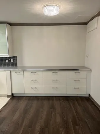 an empty room with wooden floor closet and windows