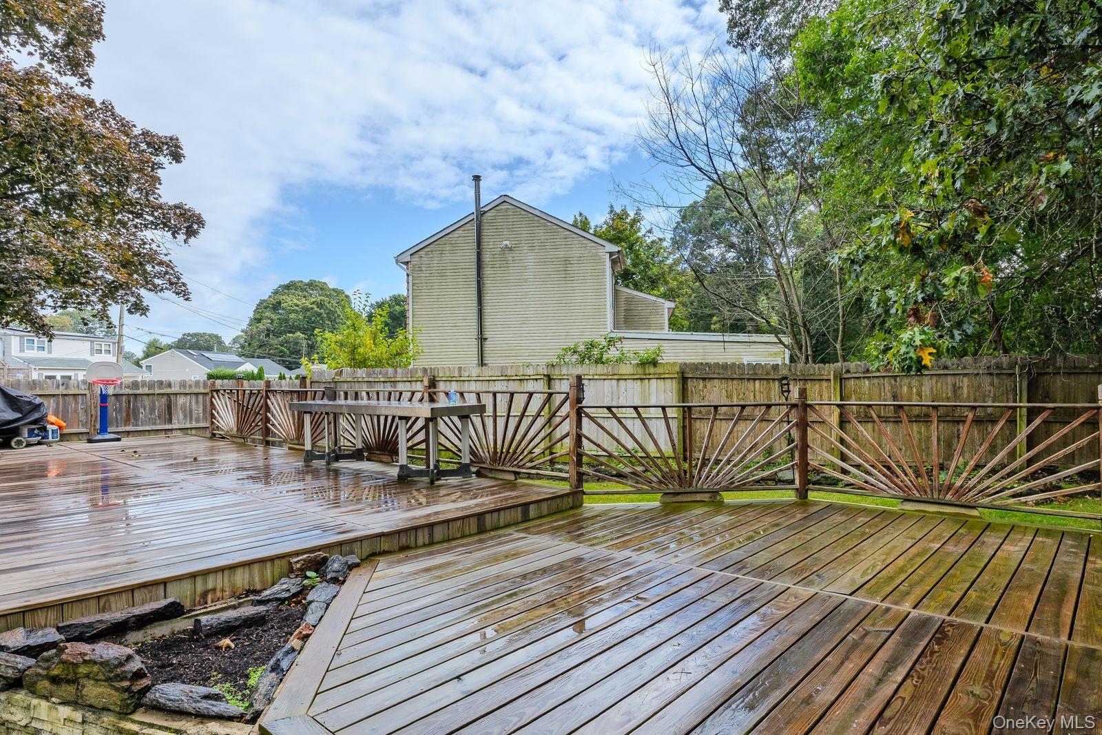 22 Larry Road Selden, NY 11784 - Photo 26 of 36 a view of a deck with wooden floor and fence next to a yard