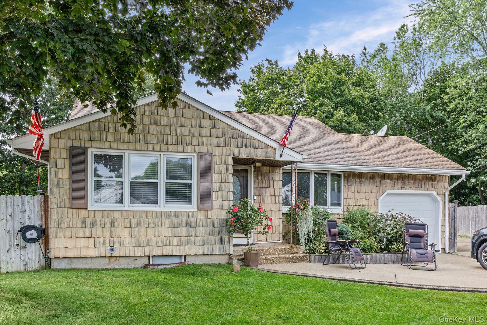 22 Larry Road Selden, NY 11784 - Photo 35 of 36 a front view of a house with a garden and plants
