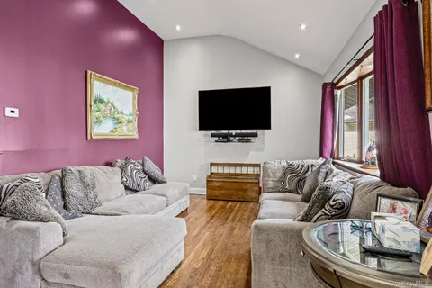 a kitchen with stainless steel appliances granite countertop a stove refrigerator a dining table and chairs with wooden floor