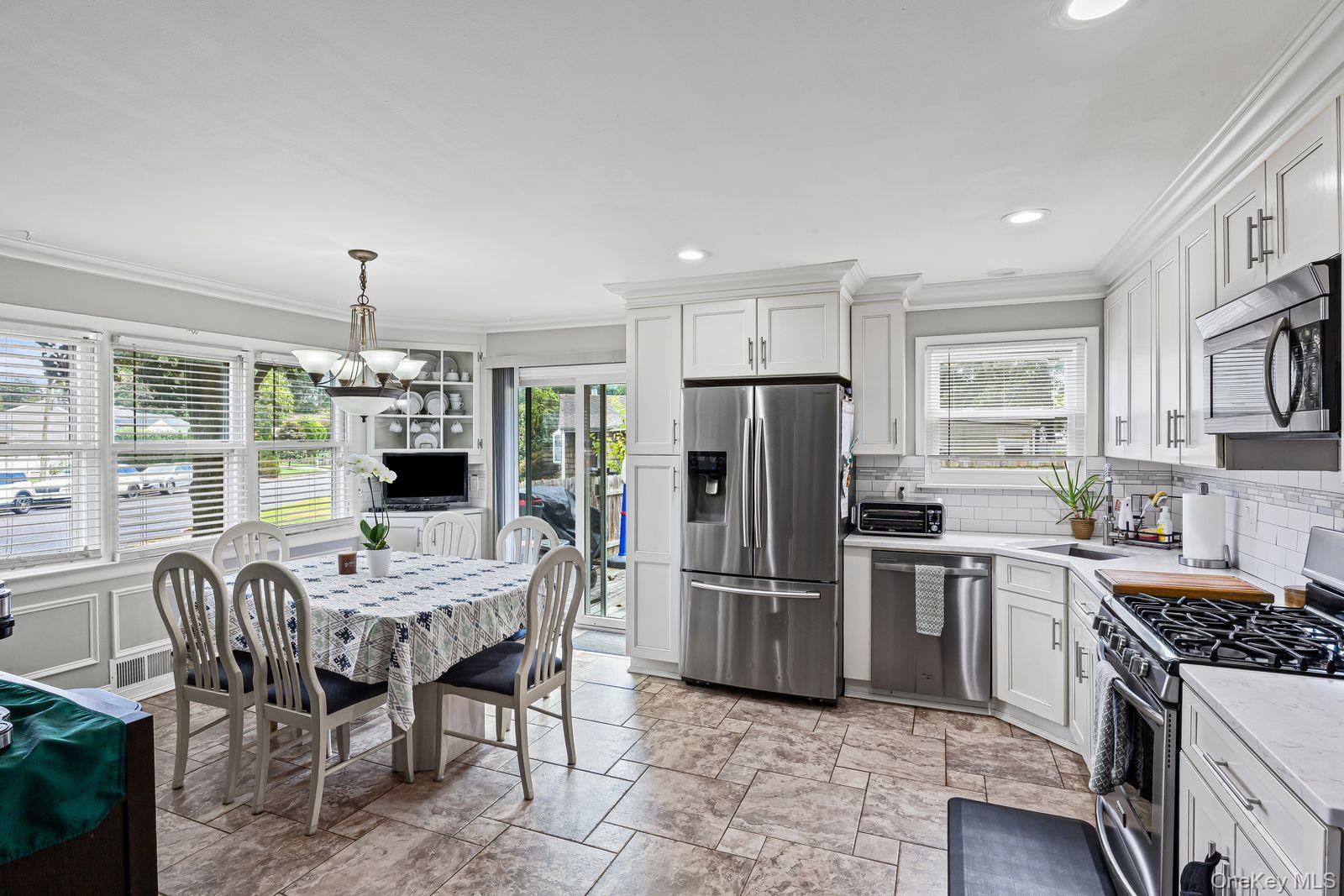 22 Larry Road Selden, NY 11784 - Photo 8 of 36 a kitchen with stainless steel appliances granite countertop a stove refrigerator a dining table and chairs with wooden floor