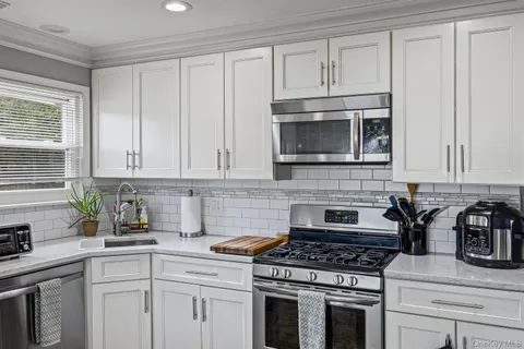 a kitchen with kitchen island granite countertop a center island a stove cabinets a dining table and chairs