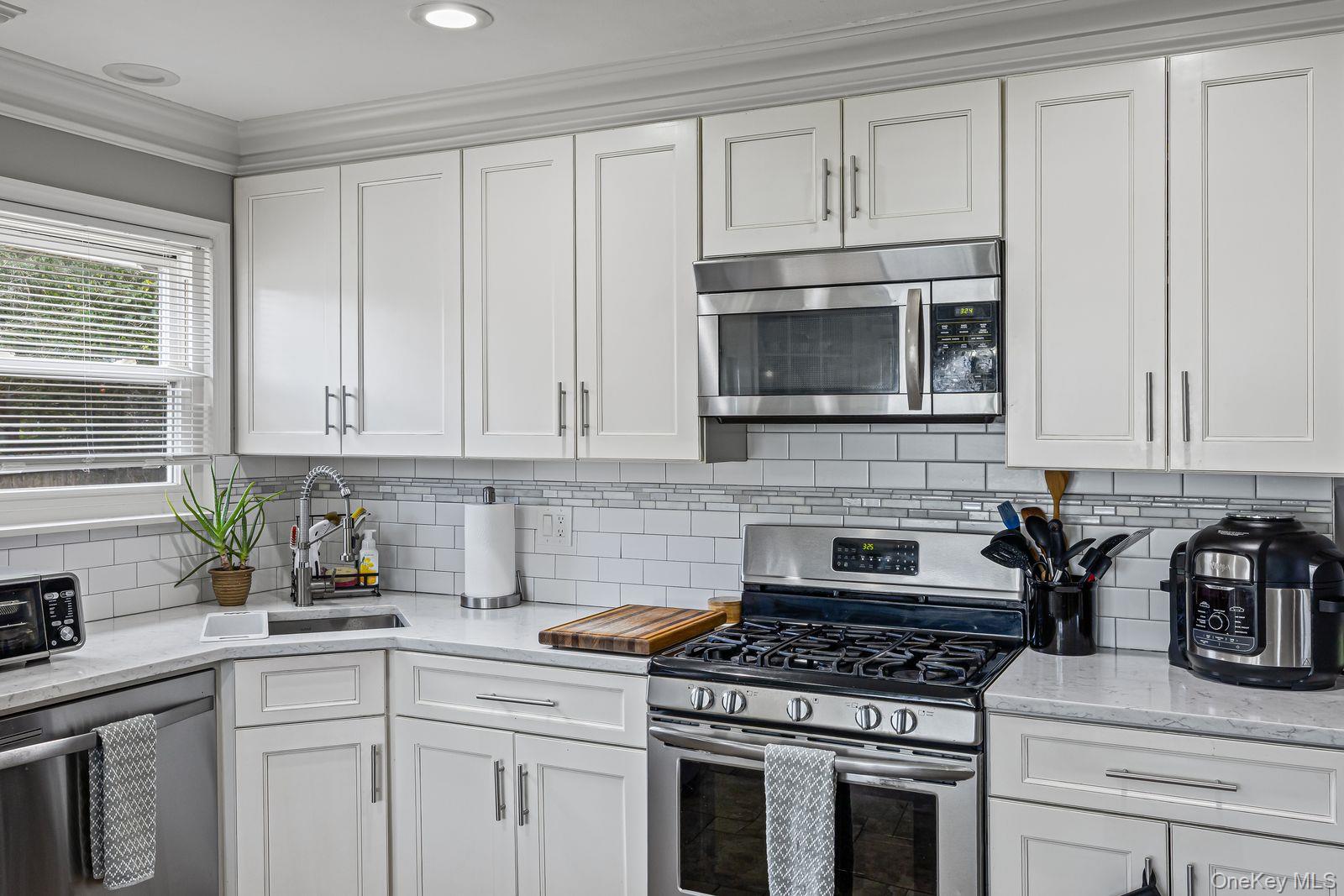 22 Larry Road Selden, NY 11784 - Photo 9 of 36 a kitchen with cabinets stainless steel appliances and a sink
